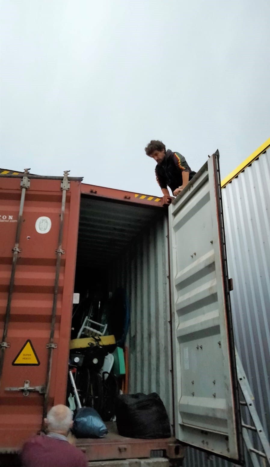 Bénévole grimpant sur la porte ouverte du container.