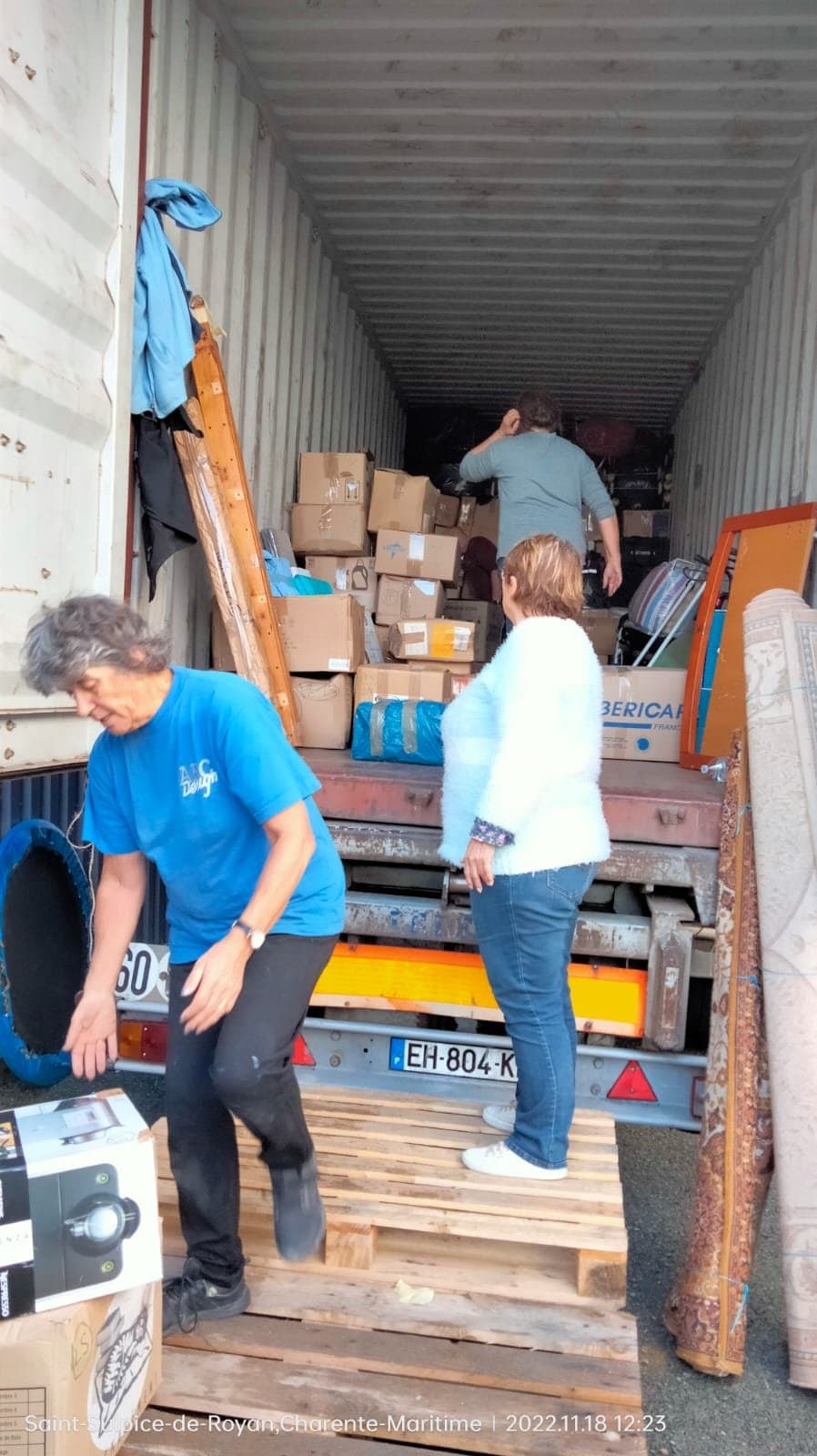 Bénévoles chargeant des cartons et des sacs dans le container.
