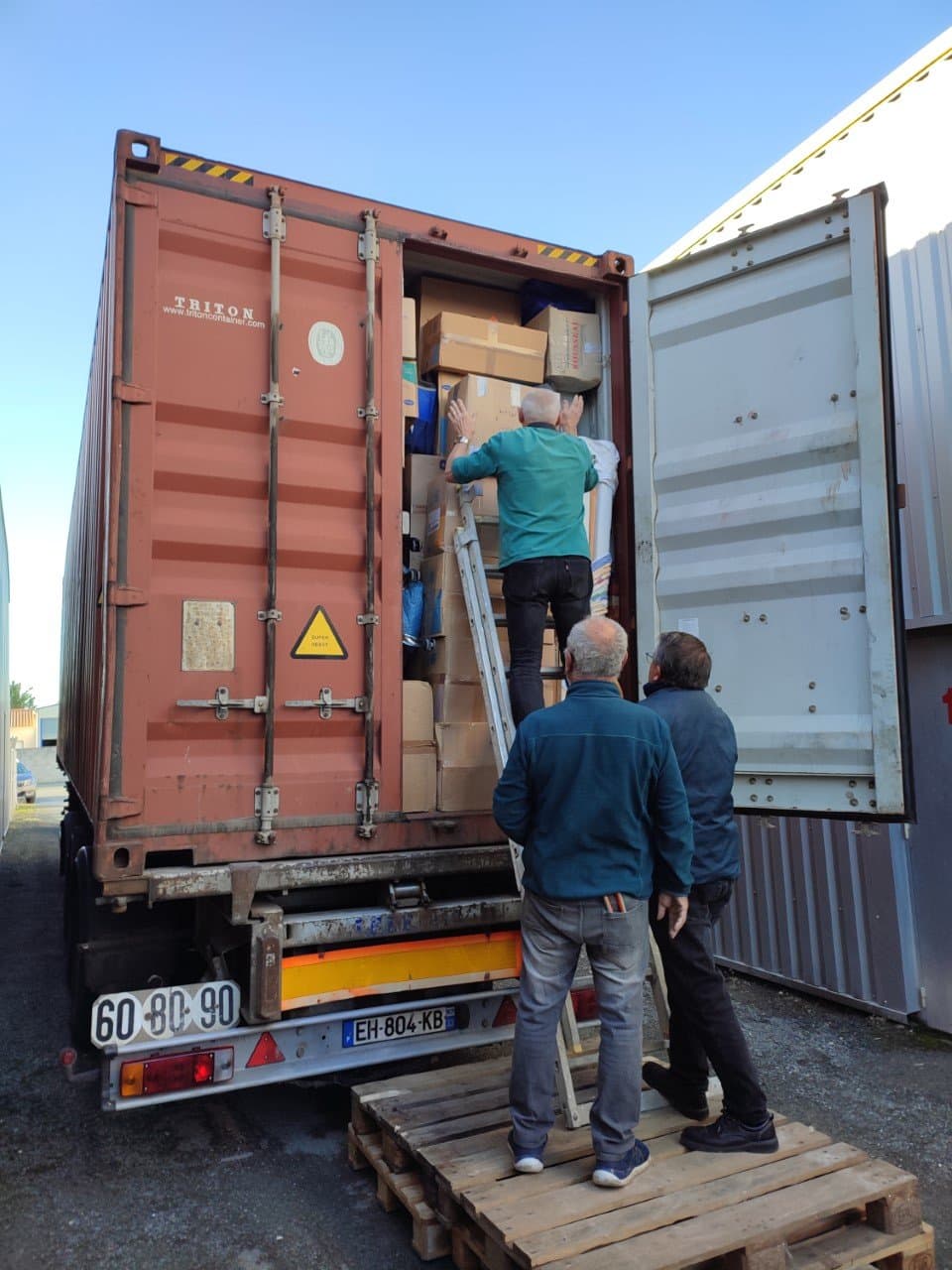 Bénévoles finalisant le chargement du container avant fermeture.