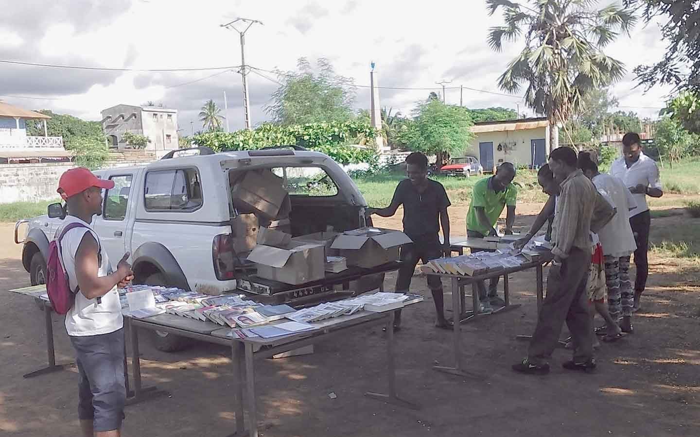 Déchargement de cartons de livres depuis un pick-up pour la distribution.