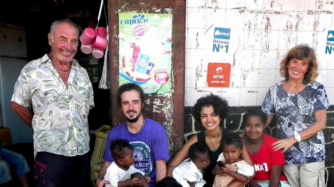 Bénévoles posant avec des enfants du quartier devant une épicerie locale.