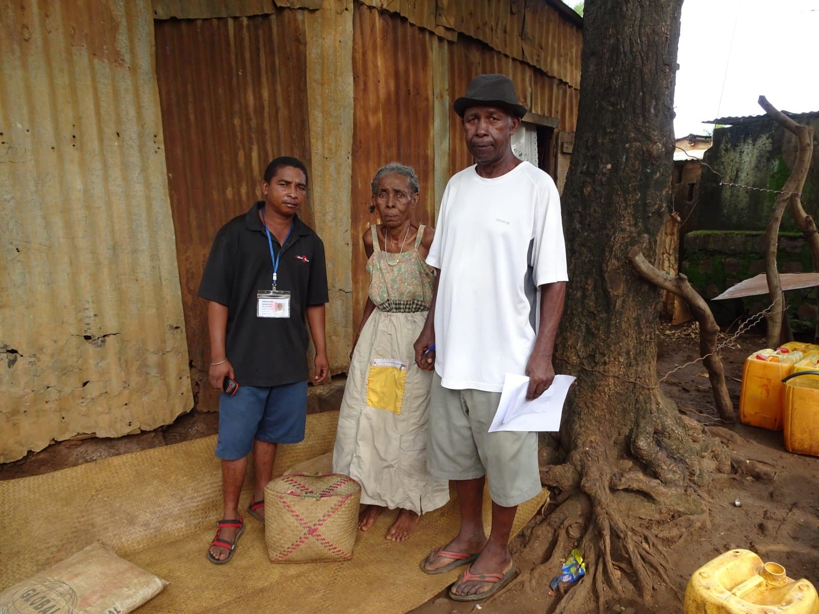 Bénévole remettant une liste à un couple devant leur habitation.