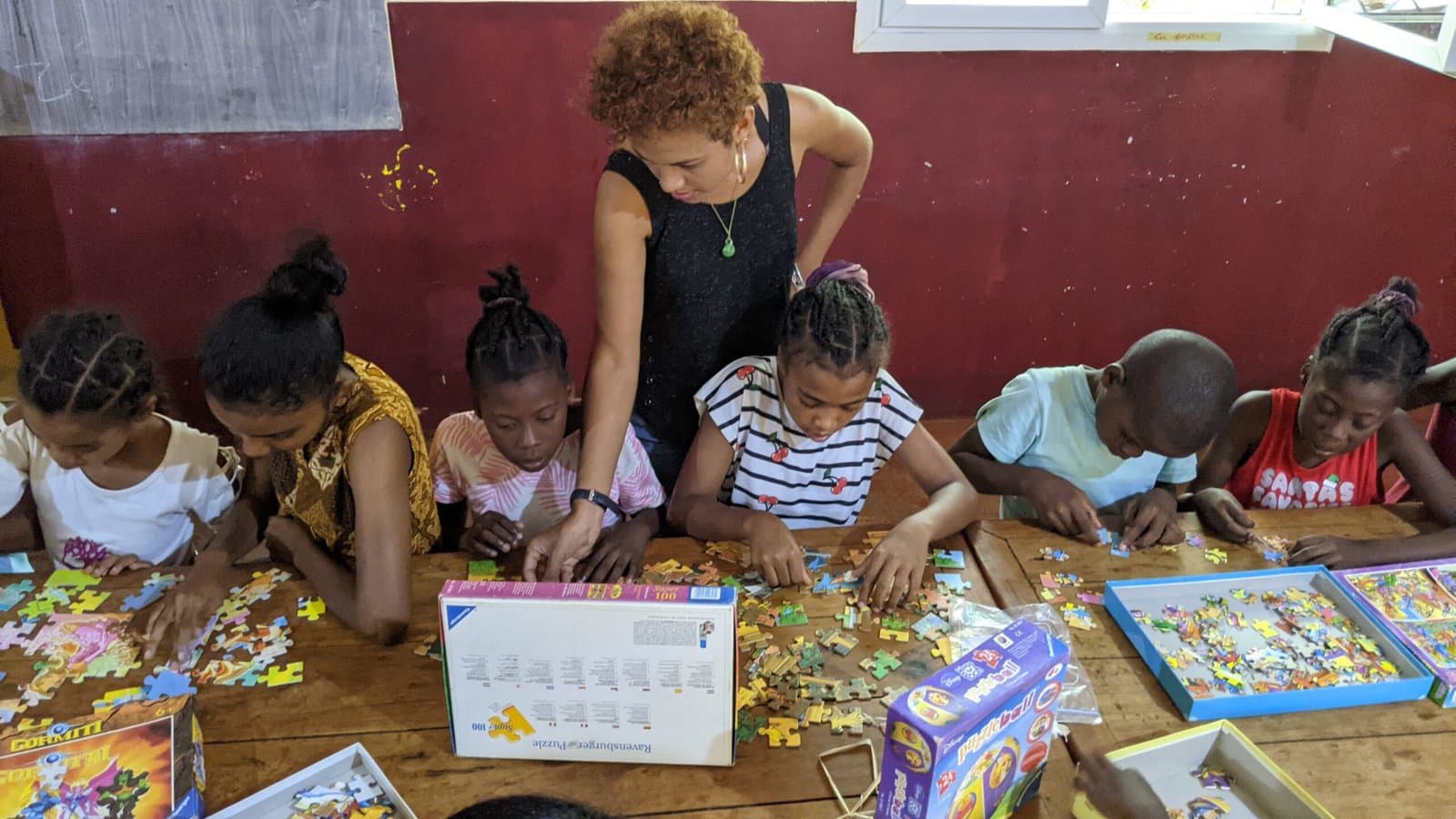 Bénévole aidant des enfants à assembler un puzzle.