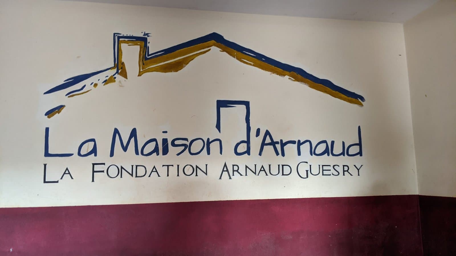 Fresque murale « Maison d'Arnaud — Fondation Arnaud Guesry » à l'entrée de l'orphelinat.