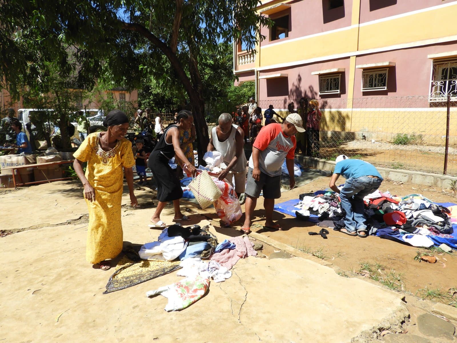 Habitants triant des vêtements étalés au sol pendant la distribution.