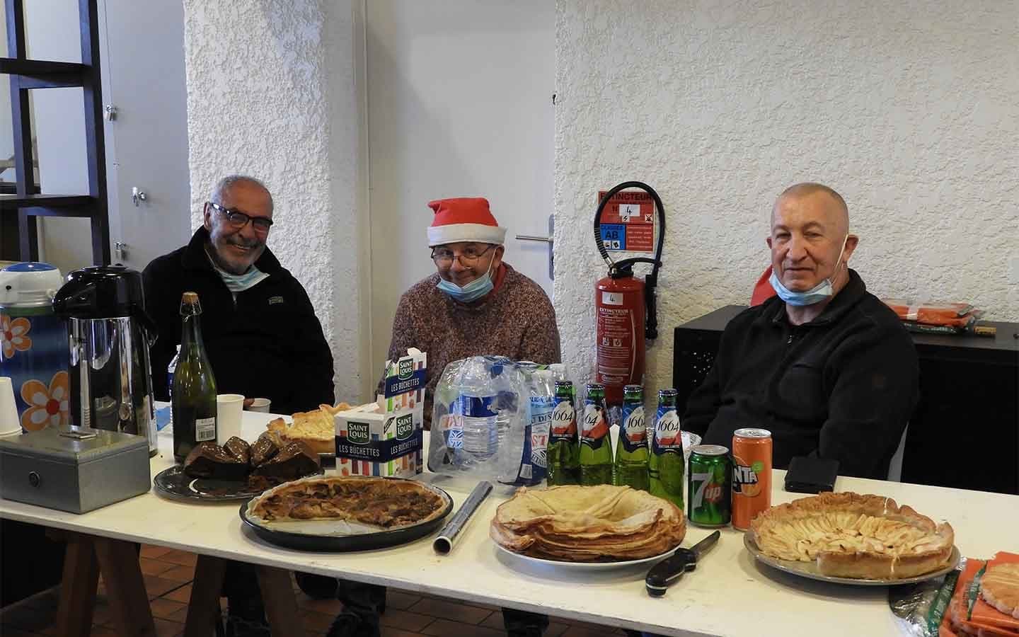 Bénévoles en pause devant un buffet lors du vide-dressing de Noël.