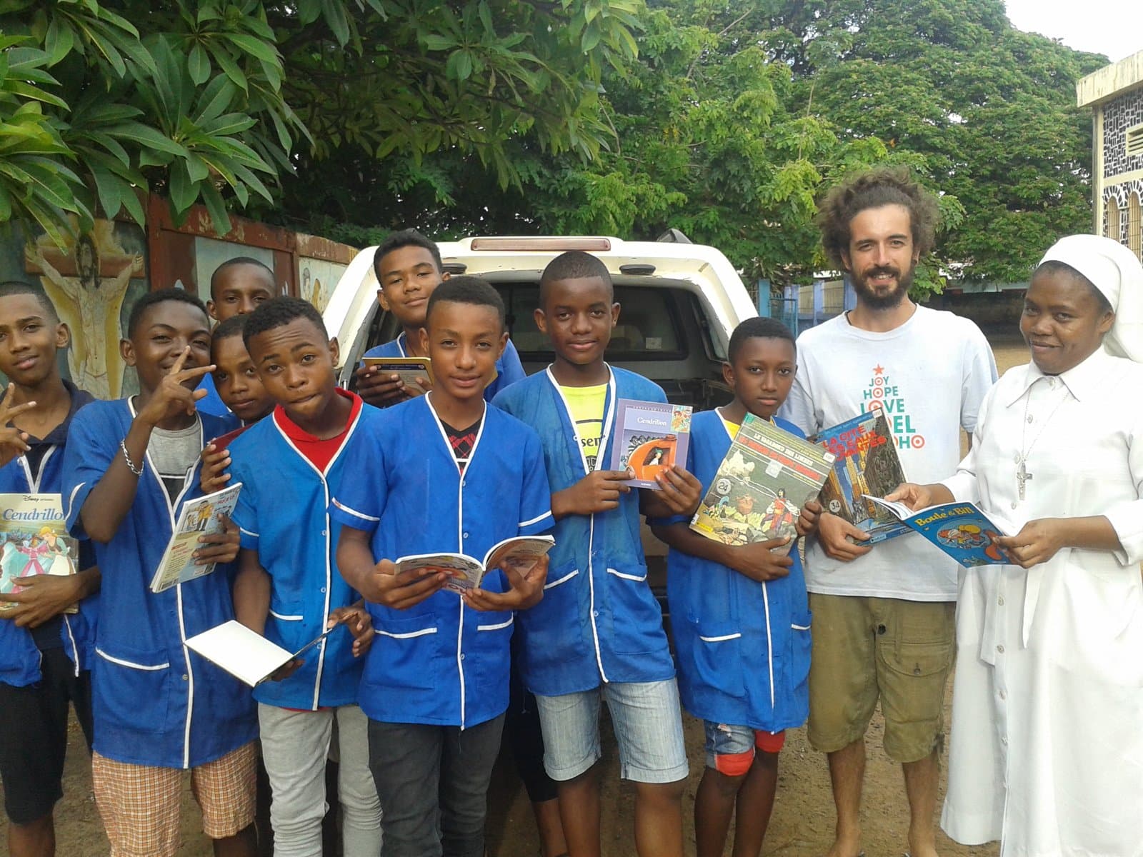 Un des fondateurs de Récup'Mada distribuant des livres à des élèves à Madagascar