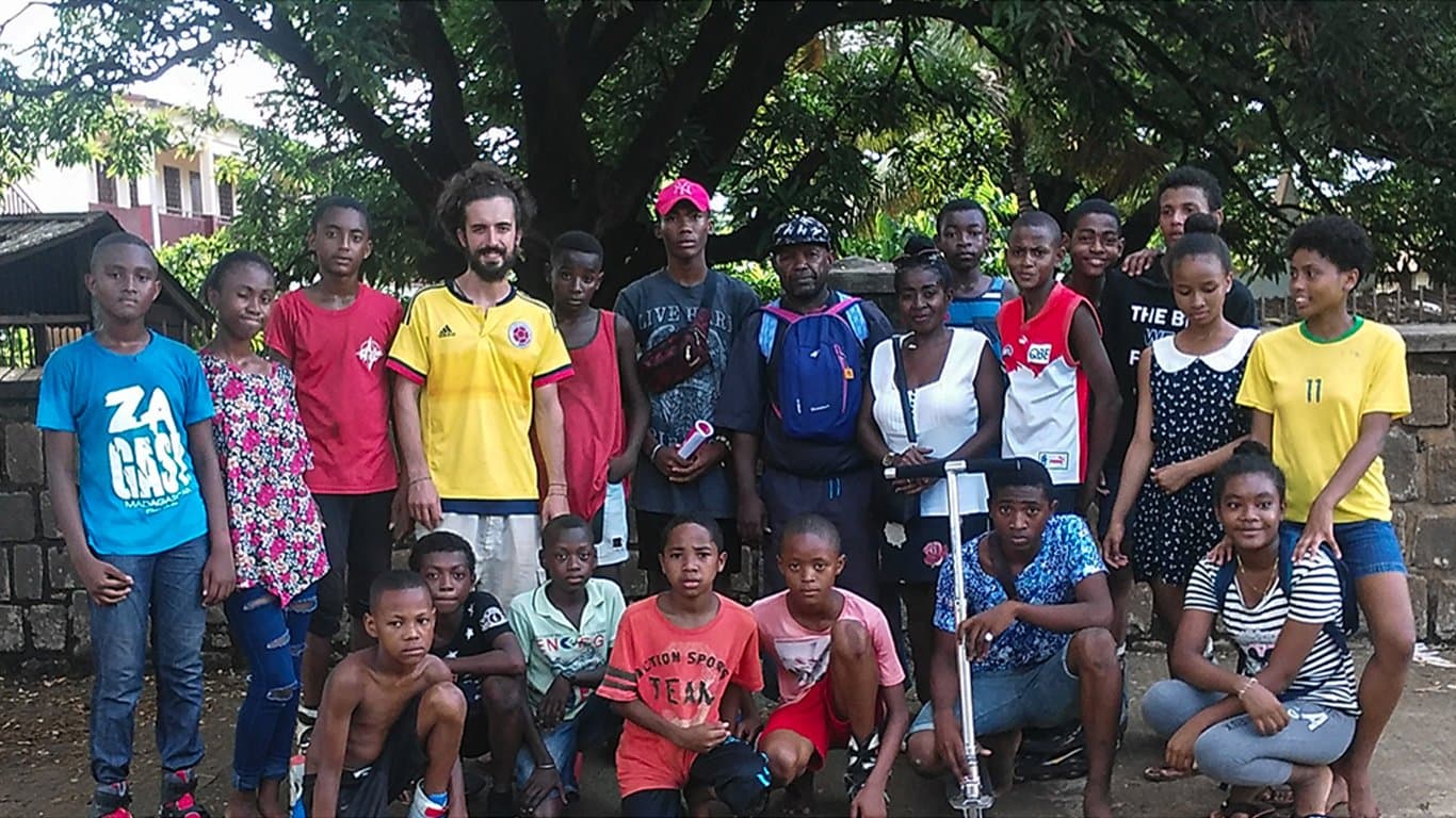 Bénévole entouré d'un groupe d'enfants du quartier.