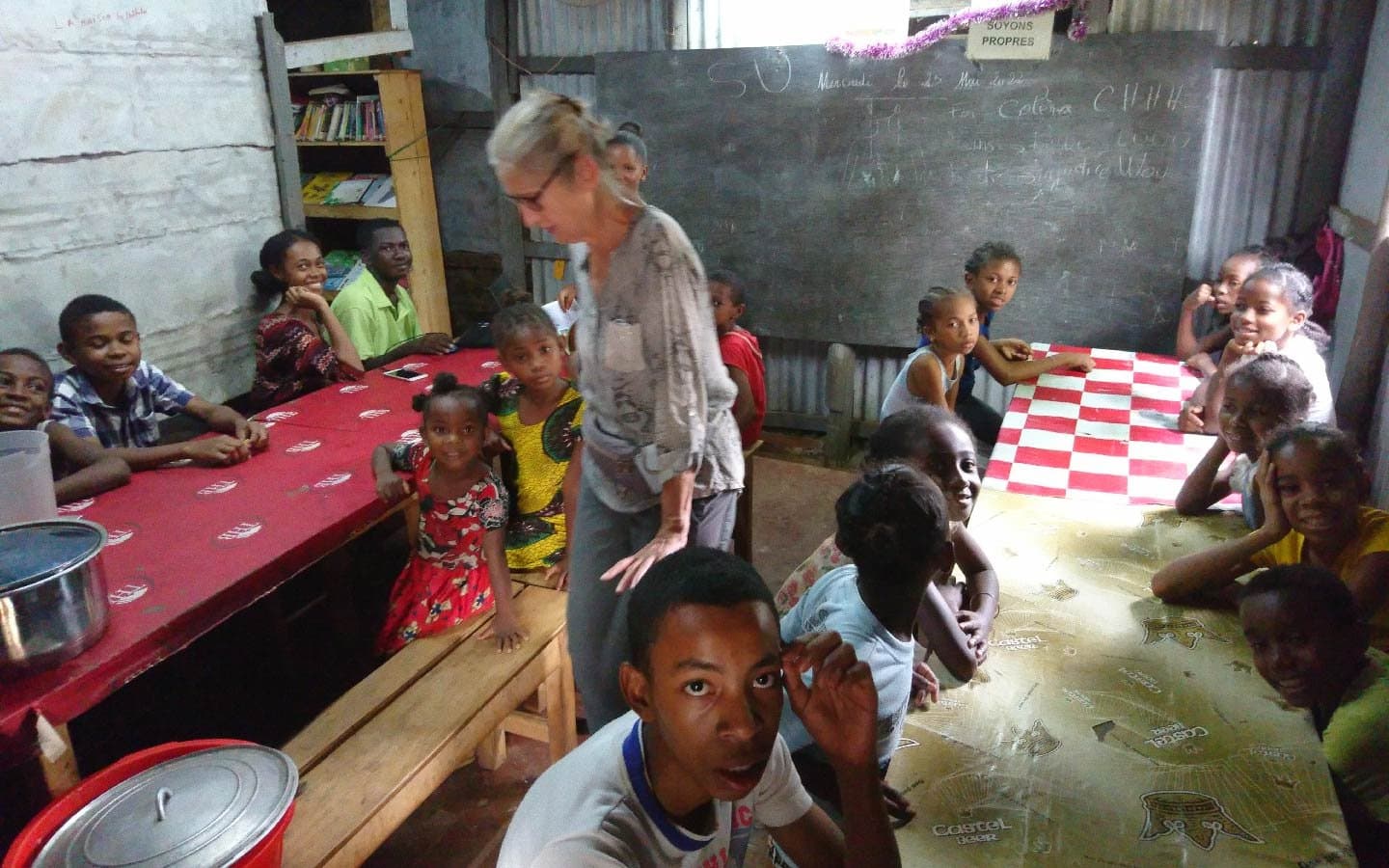 Bénévole avec des enfants dans une salle de classe du centre d'accueil.