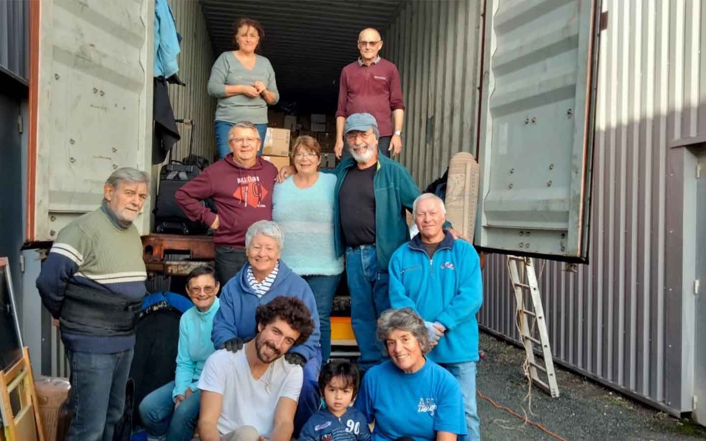 Bénévoles Récup'Mada posant devant un container en cours de chargement.